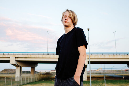 Young man against urban bridge