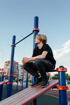 Teenager sitting on sports ground