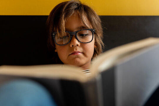 Young boy studying on the bed