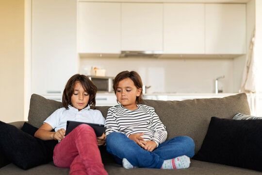 kids watching videos on a tablet at home