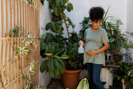 Prenatal female watering plants at home