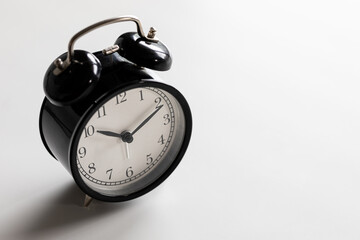 Black and white vintage classic alarm clock at ten o'clock with white space.