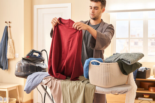 Male housekeeper examining sweatshirt