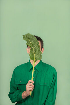 Man holding a leaf in from of his face