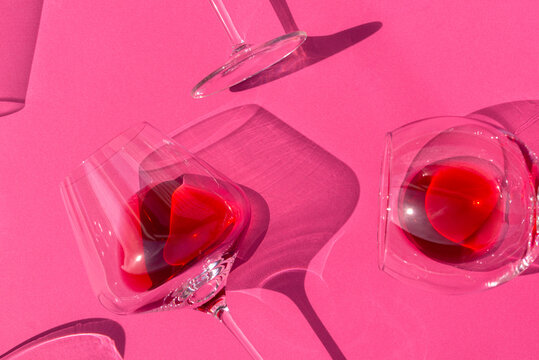 Glasses of wine on pink surface