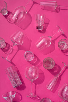 Glassware chaotically scattered on pink table