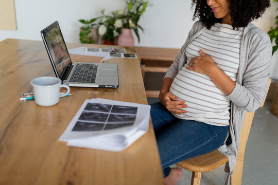 Pregnant woman looking her baby's ultrasounds 