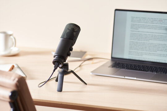 Microphone near laptop with podcast script