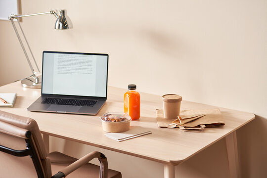 Workplace with laptop and delivery food