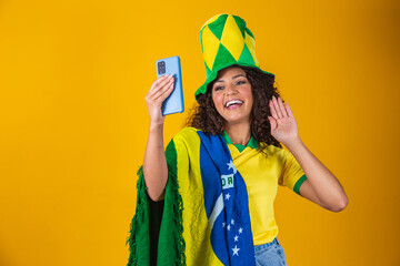 Brazil supporter. Brazilian woman fan celebrating on soccer, football match on yellow background....