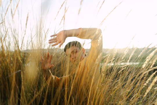 Man With Arms Extended On A Field