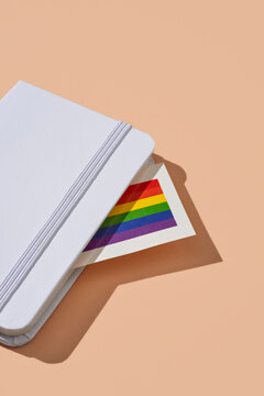 gay pride flag peeks out from a notebook