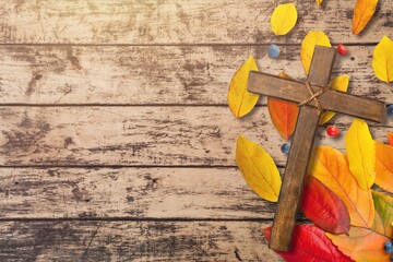 simple wood cross with border of colorful autumn leaves