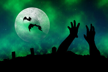 Silhouette of zombie hand raised from the ground with flying bats