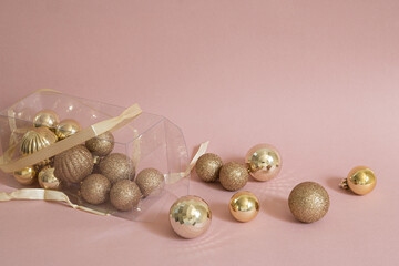golden christmas balls ornaments coming out of box, pink background