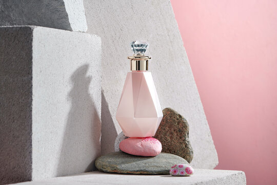 The pink perfume bottle on stone