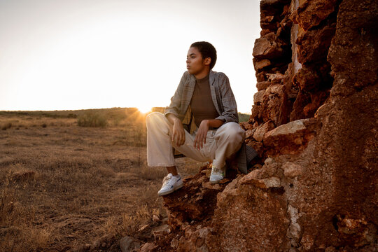 Black woman near ruins at sunset