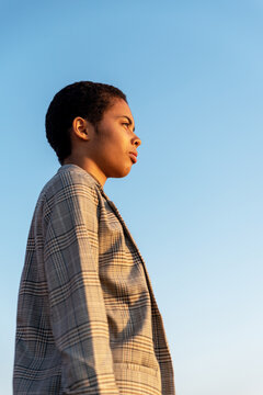 Contemplative black woman under blue sky