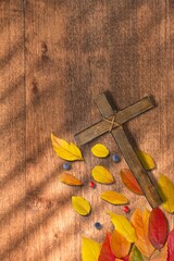 simple wood cross with border of colorful autumn leaves