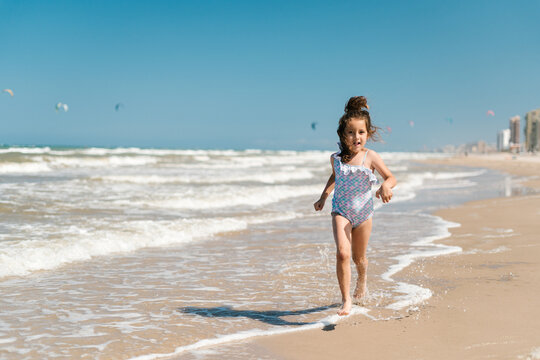 Girl running along beach in summer