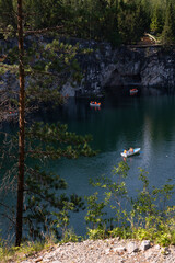 Naklejka premium Boats with tourists float on the lake of the Great Marble Canyon in the Republic of Karelia in Russia