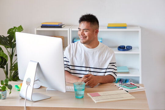 Happy man working with computer in office