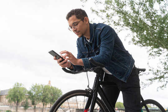 Man On Bicycle Using Phone Outdoors