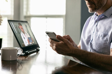 Distancing: Man Checking Doctor Information On Phone During Tele