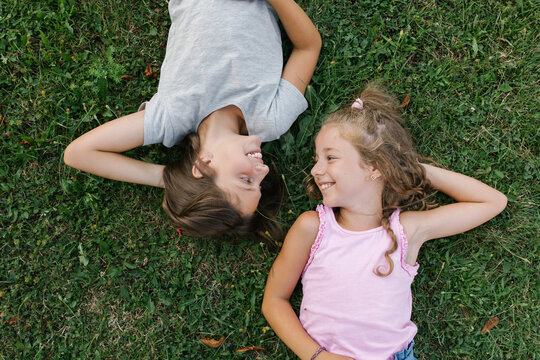 Happy girls lying on the ground looking each other