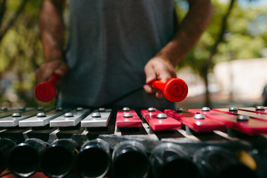 Someone playing an outdoors glockenspiel 

