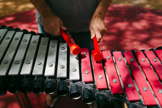 Man's hands playing an outdoors glockenspiel 
