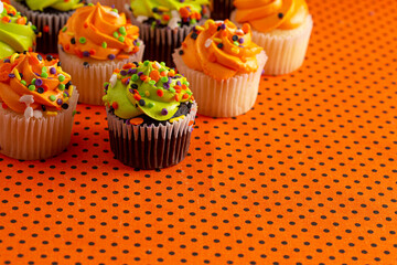 Halloween Cupcakes with Sprinkles on an Orange and Black Tablecloth