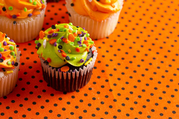 Halloween Cupcakes with Sprinkles on an Orange and Black Tablecloth