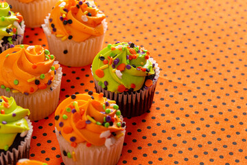 Halloween Cupcakes with Sprinkles on an Orange and Black Tablecloth