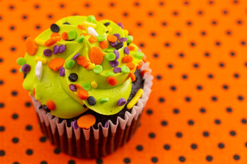 Halloween Cupcakes with Sprinkles on an Orange and Black Tablecloth