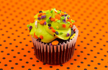 Halloween Cupcakes with Sprinkles on an Orange and Black Tablecloth