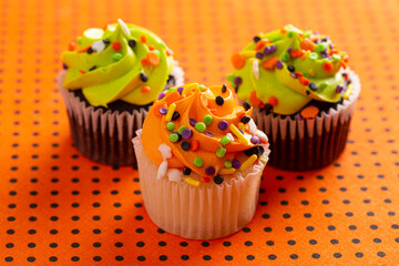 Halloween Cupcakes with Sprinkles on an Orange and Black Tablecloth