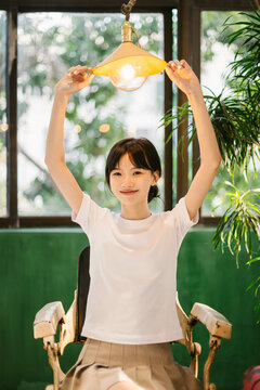 Asian woman sitting with hand on the lampshade