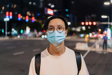 Portrait of a man wearing a mask on the street at night