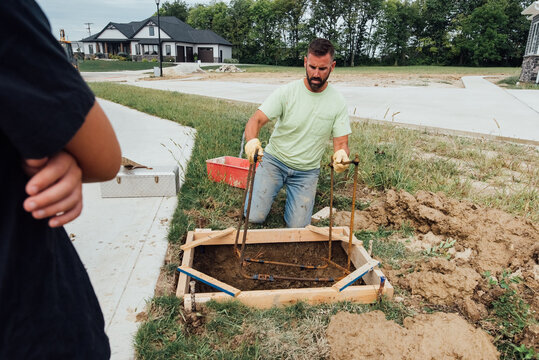 Man holding rebar frame. 