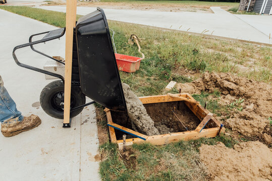 Wheelbarrow dumping concrete. 