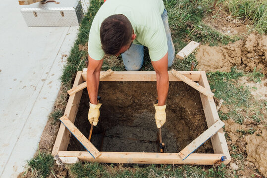 Worker places rebar in concrete. 