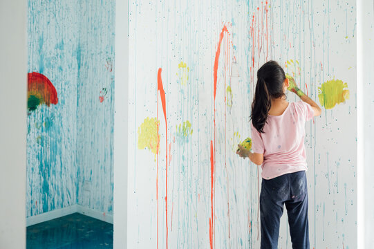 little girl painting on the wall