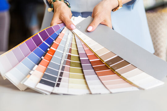Female hand holding color samples. Colored catalog fan. The concept of design work