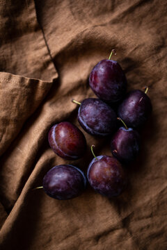 Fresh Plums on brown linen.