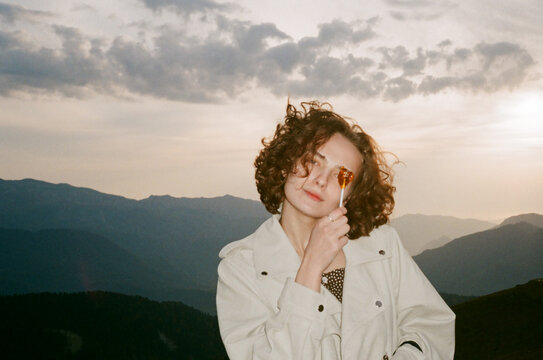 Girl over a mountain with a heart shaped lollypop 