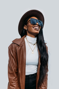 Smiling black woman in leather coat and hat