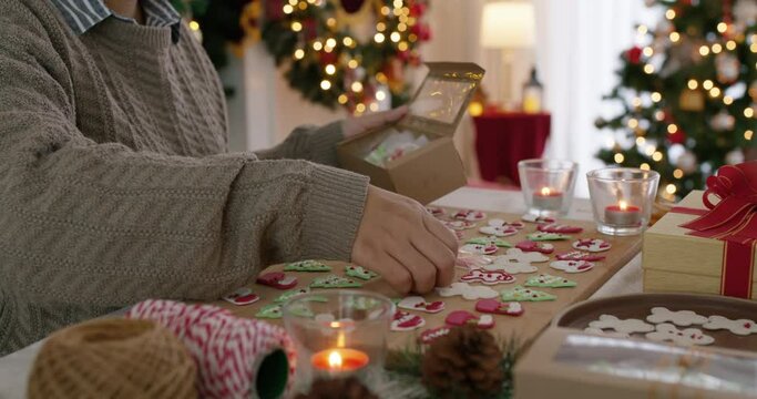 Asia happy adult people woman enjoy make craft gift for Xmas eve party snack cooking food recipe on kitchen table in good warm time. Cute smile gingerman bakery icing sugar with red green white color.