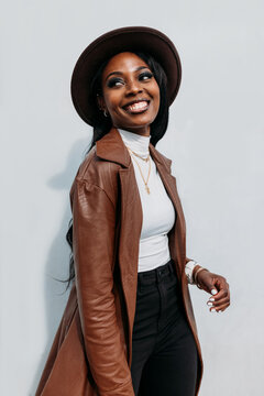 Smiling black woman in leather coat and hat