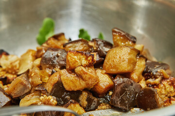 Baked, diced eggplant in bowl of arugula. Step by step recipe